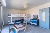 a room with bunk beds and a table and a mirror at Maison Mimizan plage in Mimizan