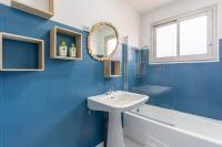 a blue bathroom with a sink and a mirror at Maison Mimizan plage in Mimizan