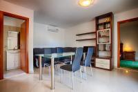 a dining room with a glass table and blue chairs at Apartments with a parking space Komiza, Vis - 12325 in Komiža