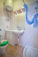 a bathroom with a sink and a toilet and a mirror at Apartments with a parking space Komiza, Vis - 12325 in Komiža