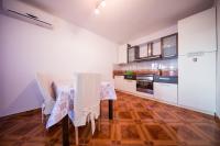 a kitchen with white cabinets and a table and chairs at Apartments with a parking space Komiza, Vis - 12325 in Komiža