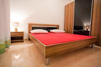a bedroom with a large wooden bed with a red mattress at Apartments with a parking space Komiza, Vis - 12325 in Komiža