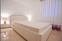a white bed in a white room with curtains at Apartments with a parking space Komiza, Vis - 12325 in Komiža