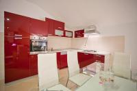 a kitchen with red cabinets and a glass table at Apartments with a parking space Komiza, Vis - 12325 in Komiža