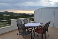 a table and chairs on a balcony with a view at Apartments with a parking space Grebastica, Sibenik - 13365 in Bašelovići
