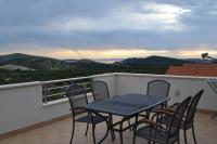 a table and chairs on a balcony with a view at Apartments with a parking space Grebastica, Sibenik - 13365 in Bašelovići