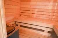 a wooden sauna with a bench in the corner at Résidence Le Lenn-louannec - Maisons &amp; Villas pour 6 Personnes 784 in Lannion
