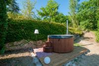 a hot tub sitting on a wooden deck at Au Bonheur Caché in Vianne