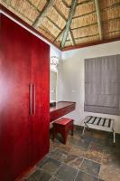 a red cabinet in a room with a desk and a bench at Manong Game Lodge in Gaborone