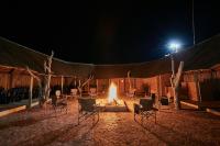 a fire pit with chairs and a tent at night at Manong Game Lodge in Gaborone