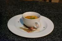 a cup of soup on a plate on a table at Manong Game Lodge in Gaborone