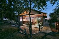a small house in the middle of a forest at Manong Game Lodge in Gaborone