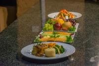 three plates of different types of food on a counter at Manong Game Lodge in Gaborone