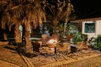 a group of chairs and a fire pit under a palm tree at Manong Game Lodge in Gaborone