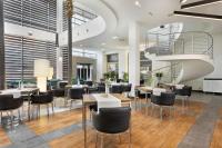 een restaurant met tafels en stoelen en een wenteltrap bij Hotel Moderno Poznań in Poznań