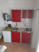 a small kitchen with red and white cabinets at Studio Sukosan 14681c in Sukošan