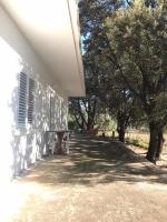 a white building with a table next to trees at Seaside secluded apartments Cove Blaca, Mljet - 615 in Saplunara