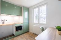 a kitchen with green cabinets and a table at Welcome perche ! Appartements 3 étoiles à NOGENT le Rotrou in Nogent-le-Rotrou