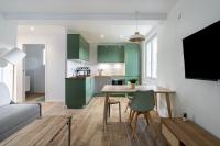 a kitchen with green cabinets and a table and chairs at Welcome perche ! Appartements 3 étoiles à NOGENT le Rotrou in Nogent-le-Rotrou