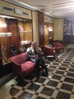 a woman sitting on a bench in a room at Hotel Amadeus in Venice