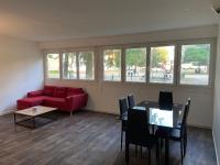 a living room with a red couch and a table at Bel appartement spacieux, lumineux avec parking in Ris-Orangis