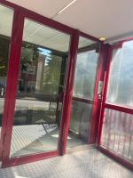 a red door of a building with glass windows at Cocon Accès facile Parking Gratuit in Belfort