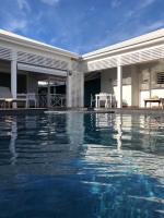 a swimming pool in front of a house at Hôtel La Christophine in Saint-François