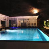 a swimming pool at night with a house at Hôtel La Christophine in Saint-François