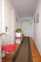 a hallway with red chairs and a table with a rug at Apartments and rooms by the sea Komiza, Vis - 2431 in Komiža