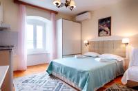 a bedroom with a bed with blue sheets and a window at Apartments and rooms by the sea Komiza, Vis - 2431 in Komiža