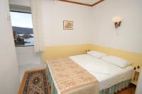 a small bedroom with a bed and a window at Apartments and rooms by the sea Komiza, Vis - 2431 in Komiža