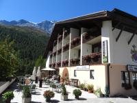 un hotel con tavoli, sedie e fiori di fronte di Alpina Mountain Resort a Solda