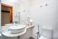 a white bathroom with a sink and a toilet at Barra do Piuva Porto Hotel in Ilhabela