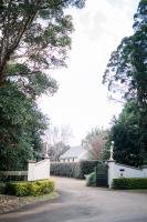 a driveway leading to a house with a gate at Shambala Estate Cottages in Mount Tamborine