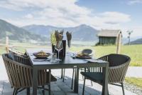 a table with chairs and food on a patio at Bergdorf Hotel Zaglgut in Kaprun