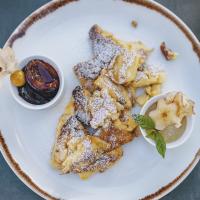 a plate of food with french toast with powdered sugar at Bergdorf Hotel Zaglgut in Kaprun
