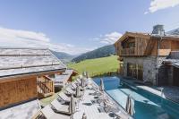 a view of the pool and patio of a mountain house at Bergdorf Hotel Zaglgut in Kaprun