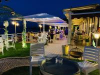eine Terrasse mit Tisch und Stühlen und Menschen, die draußen sitzen in der Unterkunft Hotel Aquila D'Oro Desenzano in Desenzano del Garda