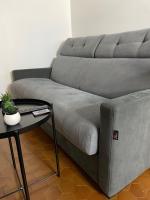a gray couch sitting in a living room with a table at Appartement Rouen Le Voltaire Home in Rouen