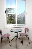 a table and two chairs in front of a window at Apartments with a parking space Podaca, Makarska - 4747 in Podaca