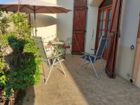 a patio with a table and chairs and an umbrella at Bompastor in Bompas