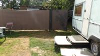 a fence next to a rv and a trailer at Calme de la campagne in Le Torp-Mesnil