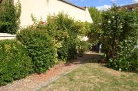 a garden with bushes and flowers in front of a house at L&#39;essentiel de Chartres in Chartres