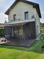 a house with a wooden deck with chairs on it at Vila pod Černou horou in Rožnov pod Radhoštěm