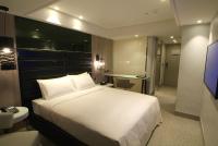 a hotel room with a bed and a bathroom at The Cloud Hotel in Taichung