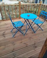 a blue table and two chairs on a deck at Gîte atypique en bois entre ville et verdures in La Chapelle-Saint-Mesmin