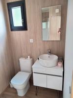 a bathroom with a toilet and a sink and a mirror at Gîte atypique en bois entre ville et verdures in La Chapelle-Saint-Mesmin