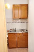 a small kitchen with a sink and wooden cabinets at Double Room Krk 5294b in Krk