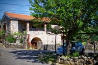 a blue car parked in front of a stone house at Apartments with a parking space Zupanje, Krk - 5307 in Županje