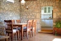 a dining room with a table and chairs and a stone wall at Apartments with a parking space Zupanje, Krk - 5307 in Županje